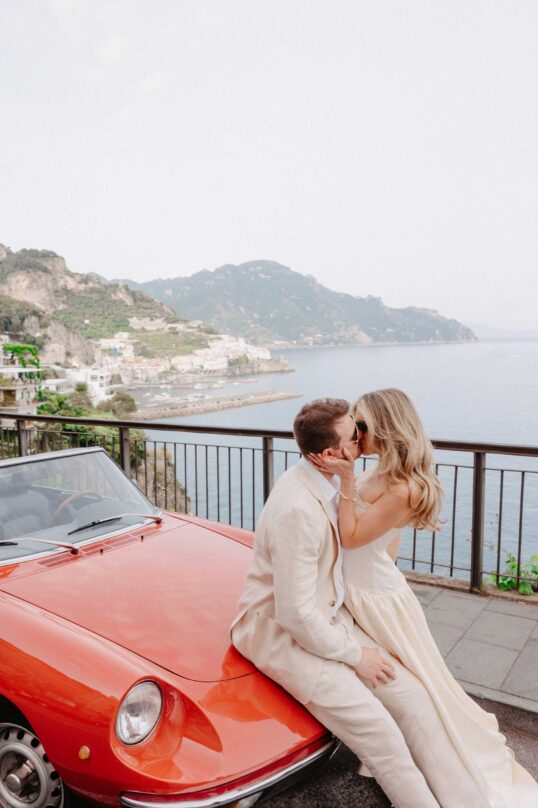 10_JIN_3175 Bride and groom with a Positano Vintage car overlooking the Amalfi Coast